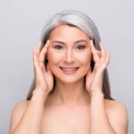 Older woman pulling her face up.